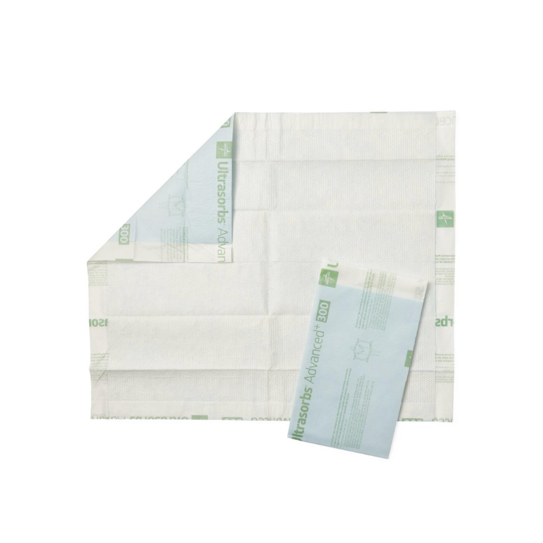 A large white Medline Ultrasorbs Advanced+ Premium Underpad, partially unfolded, with a smaller blue and white pad on top—both featuring superabsorbent polymer cores for superior patient care.